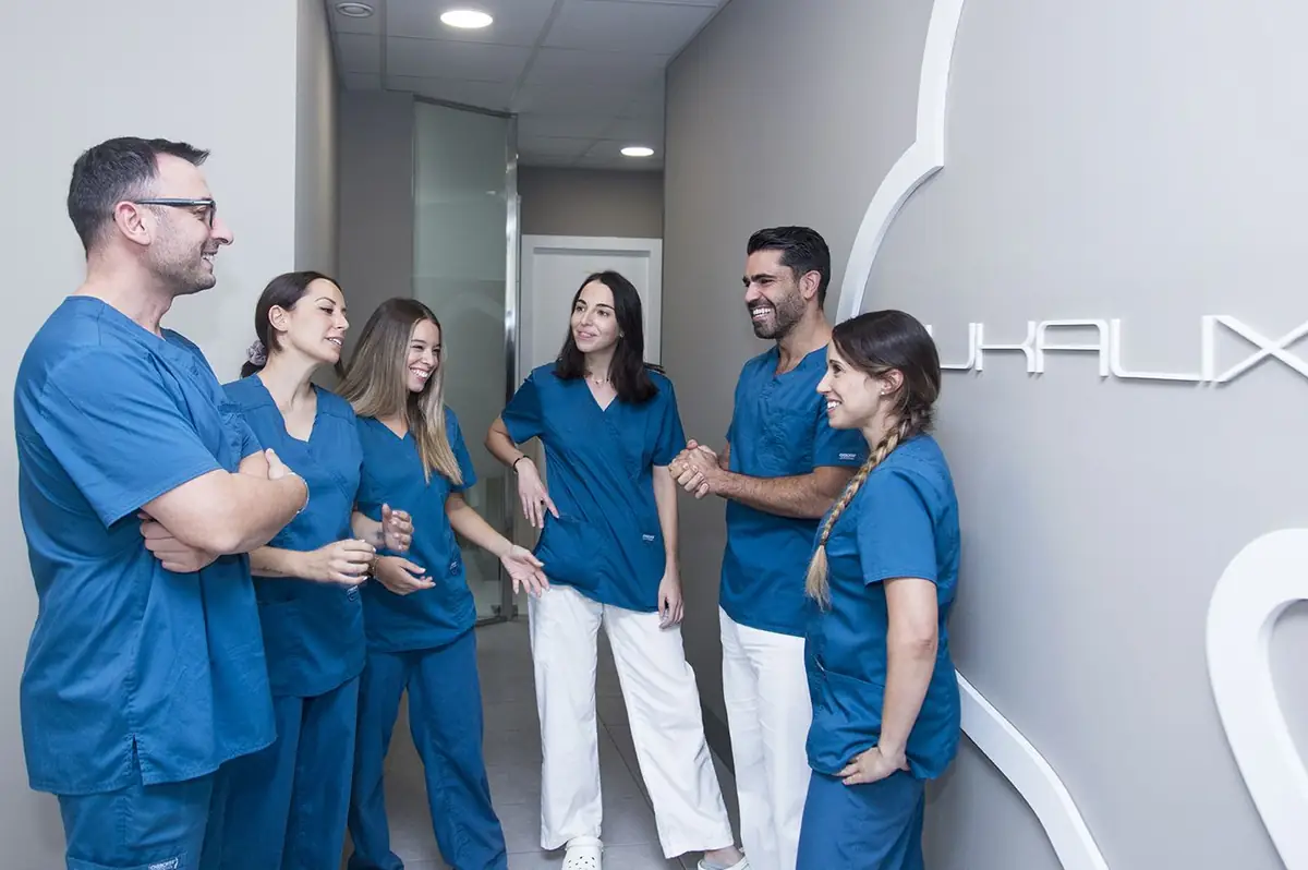 El equipo de Bukalix en el pasillo de la clínica, junto a la escultura del diente en la pared