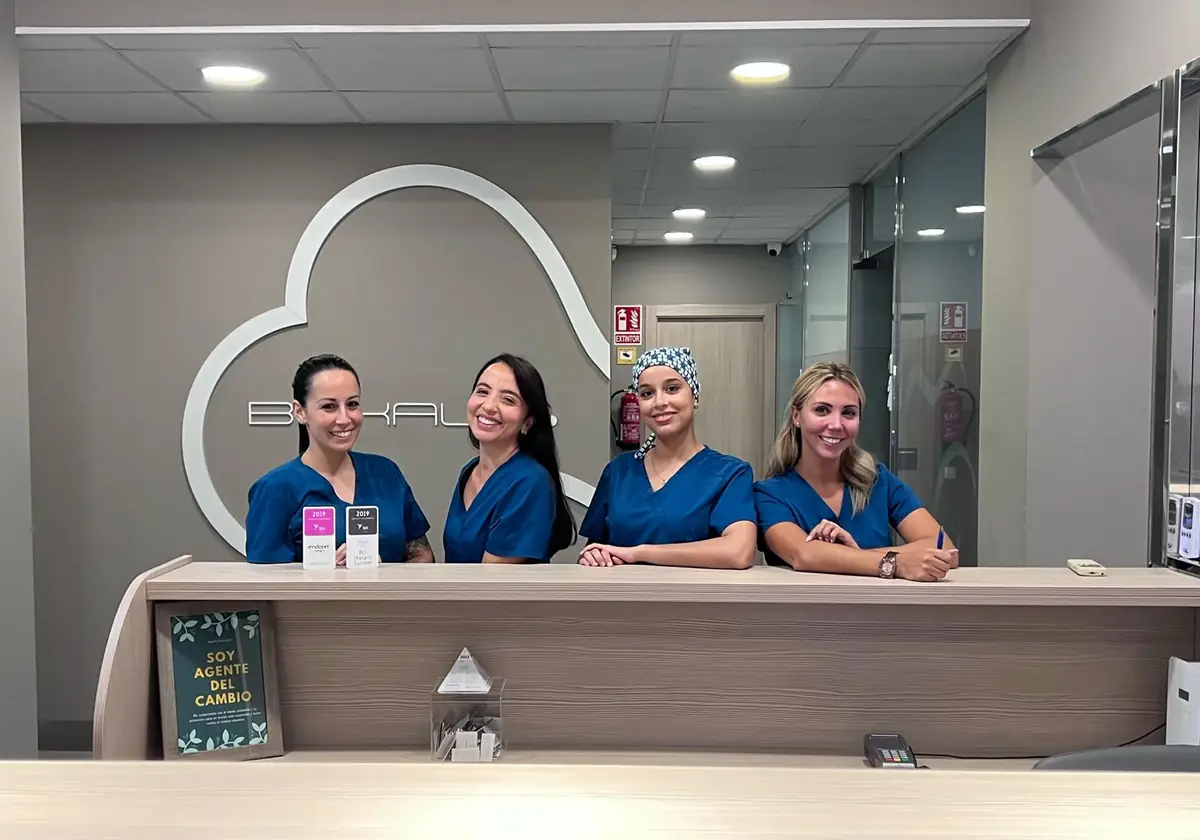 Recepción de Bukalix con el equipo y el logotipo de la clínica en la pared